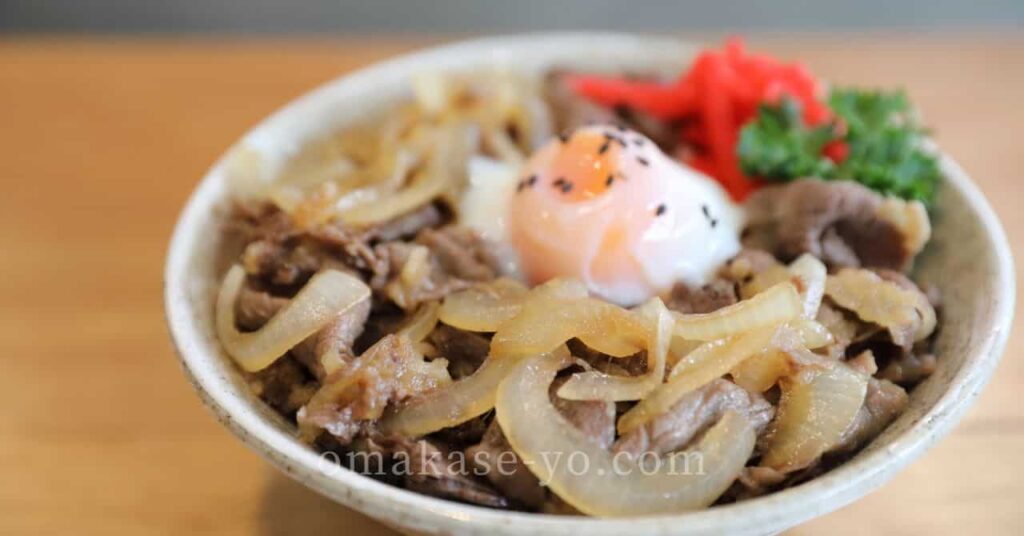 温泉卵と紅しょうがを添えた牛丼、安い肉でも美味しく仕上がる工夫を伝えるイメージ写真 
