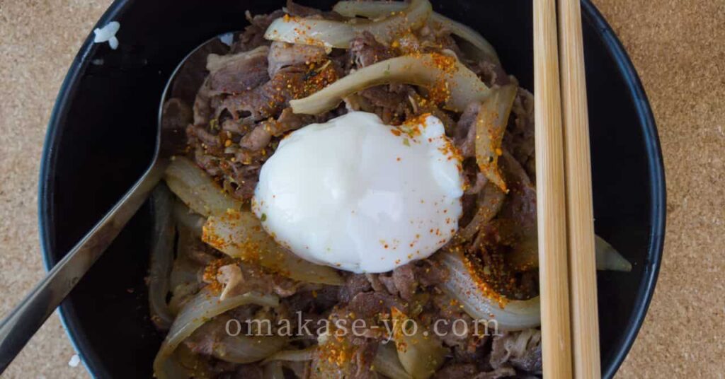 温泉卵と七味がのった牛丼、ご飯とのバランスの良さを伝えるトップビューの写真 