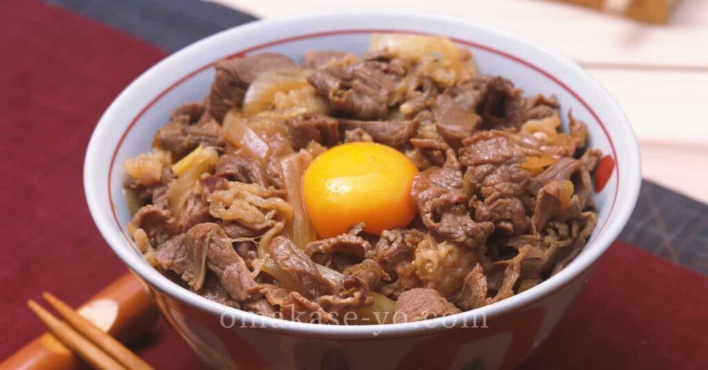 生卵がのった牛丼のアップ、旨味を引き出す調味料の工夫をイメージさせる写真 