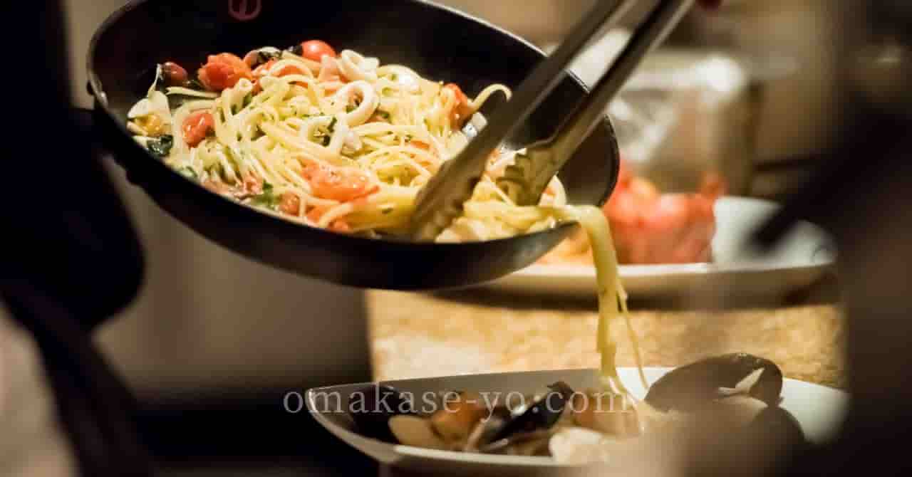 調理中のパスタをトングで皿に盛りつけている様子。うなぎにこだわらず、自分らしい土用の丑の日の過ごし方を提案する記事に最適なイメージ。